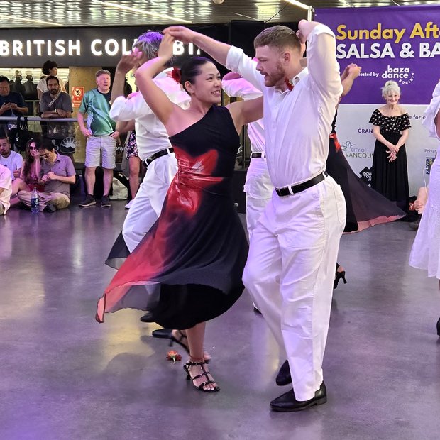 Jake mid-turn with his partner during a salsa performance at a Sunday afternoon social in Vancouver.